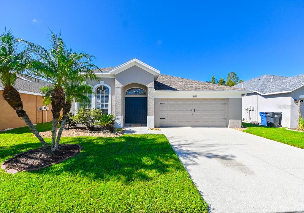 a front view of a house with a yard and garage