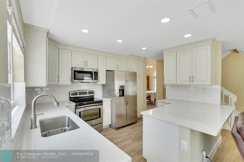 a kitchen that has a sink cabinets counter space and stainless steel appliances