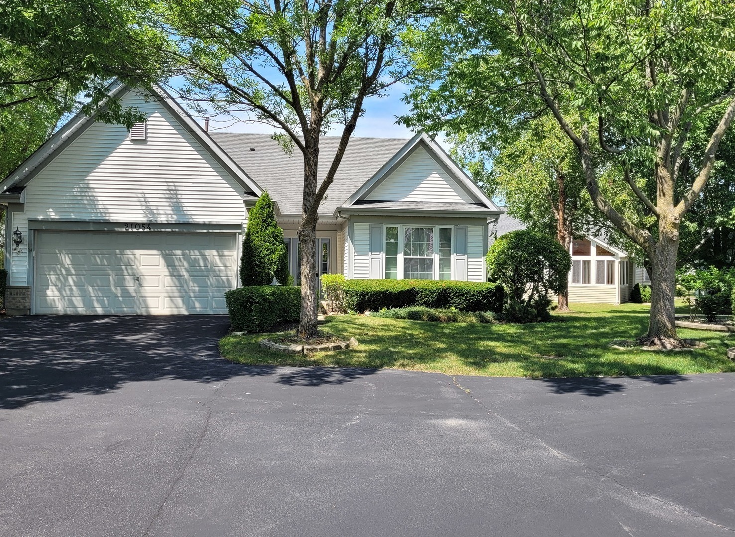 a front view of a house with a yard and trees