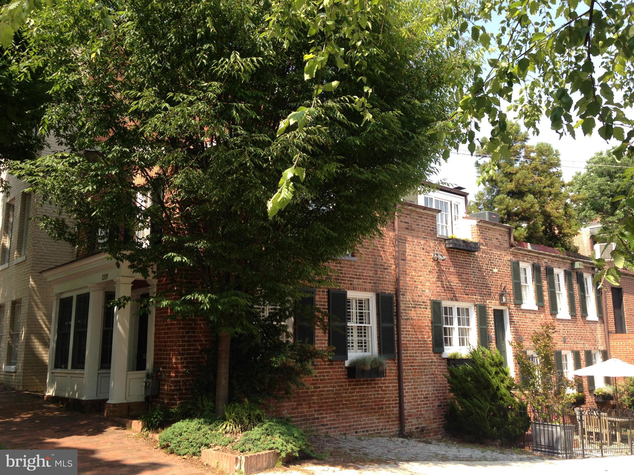 a front view of a house with a tree