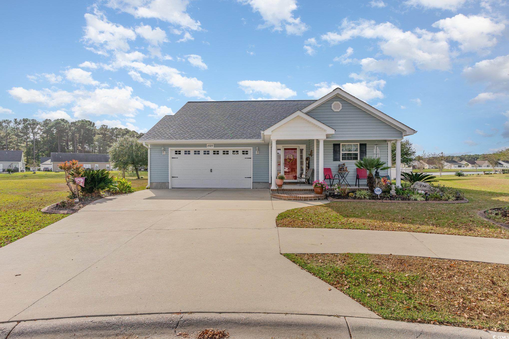 View of front of home with a garage, a front lawn,