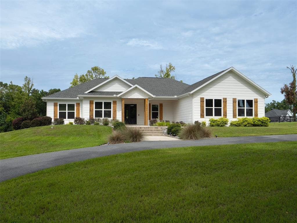 a front view of a house with a yard and green space