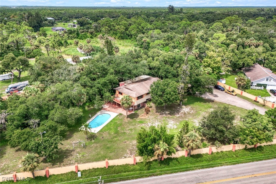 an aerial view of residential houses with outdoor space and trees