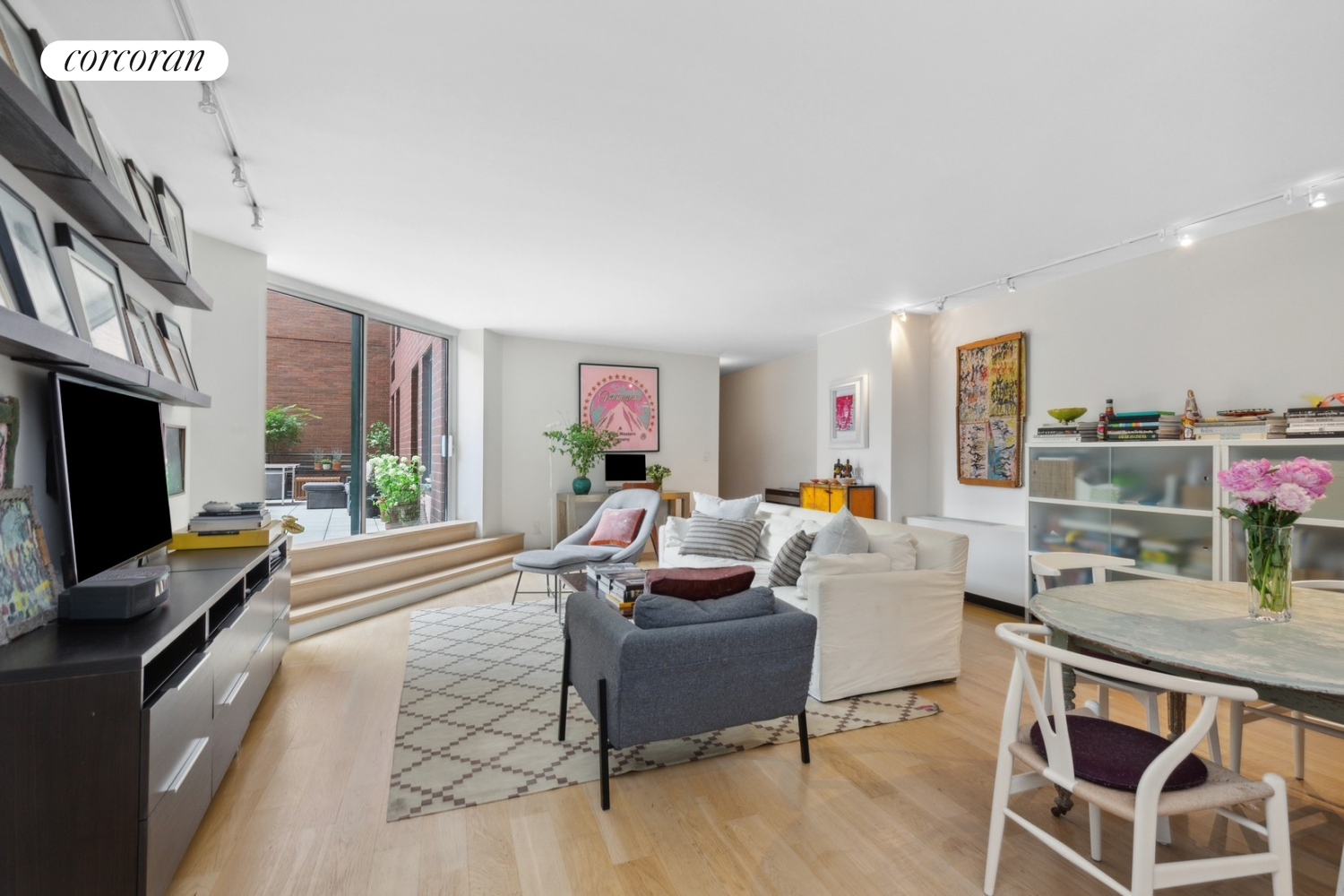 a living room with furniture a flat screen tv and kitchen view