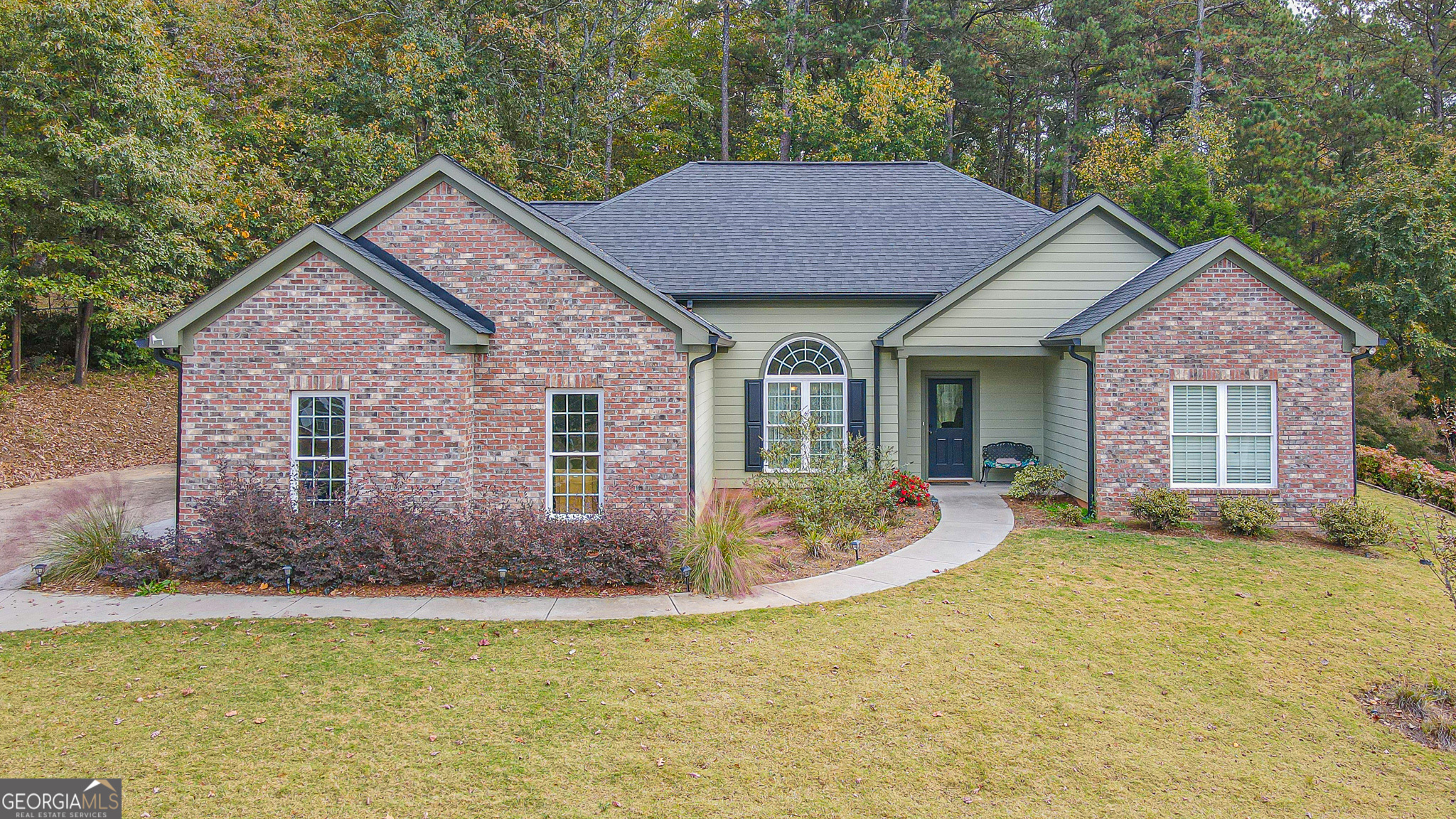 a front view of a house with a garden and yard