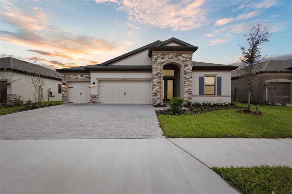 a front view of a house with a yard and garage