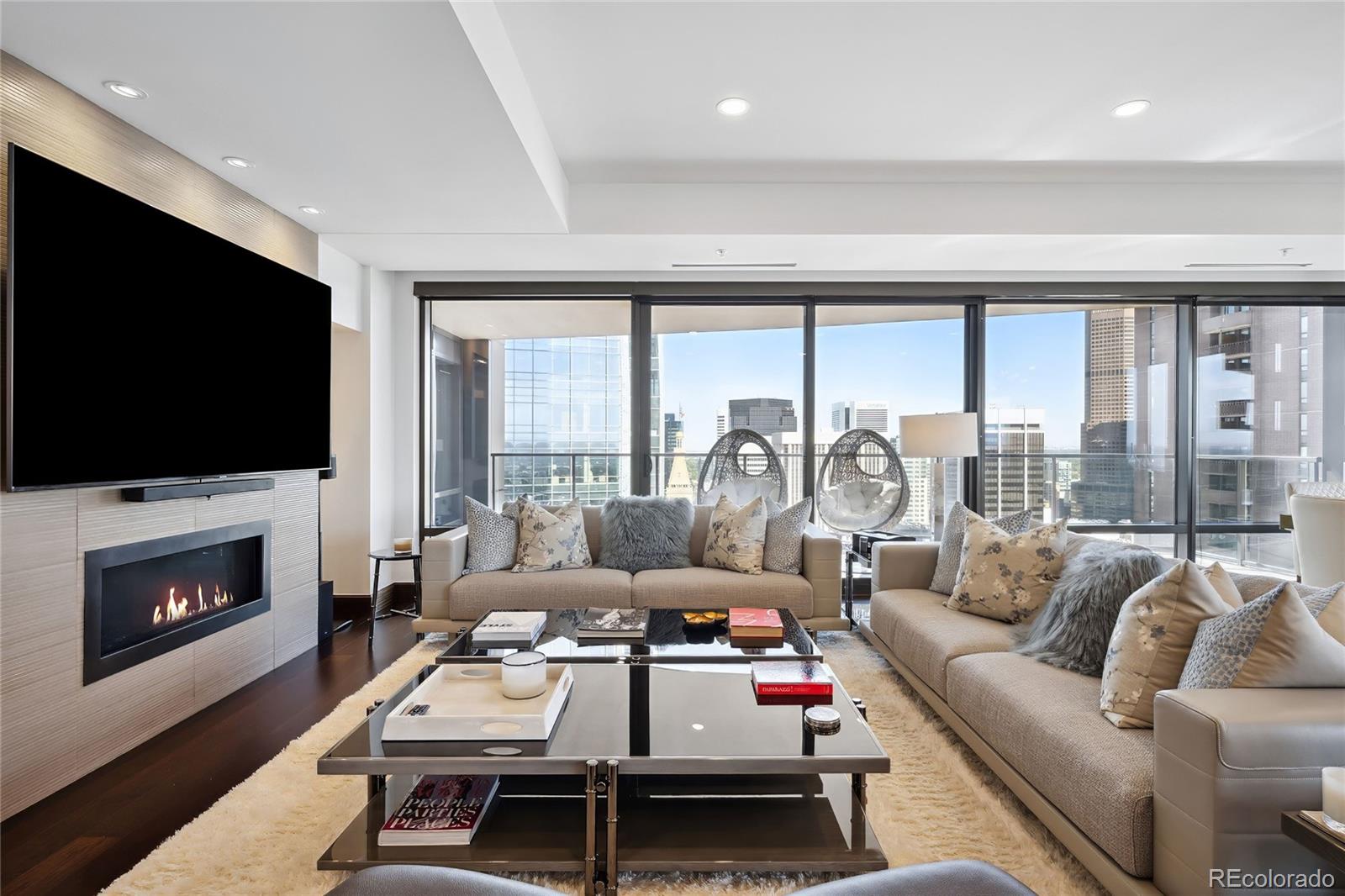 a living room with furniture a flat screen tv and a fireplace