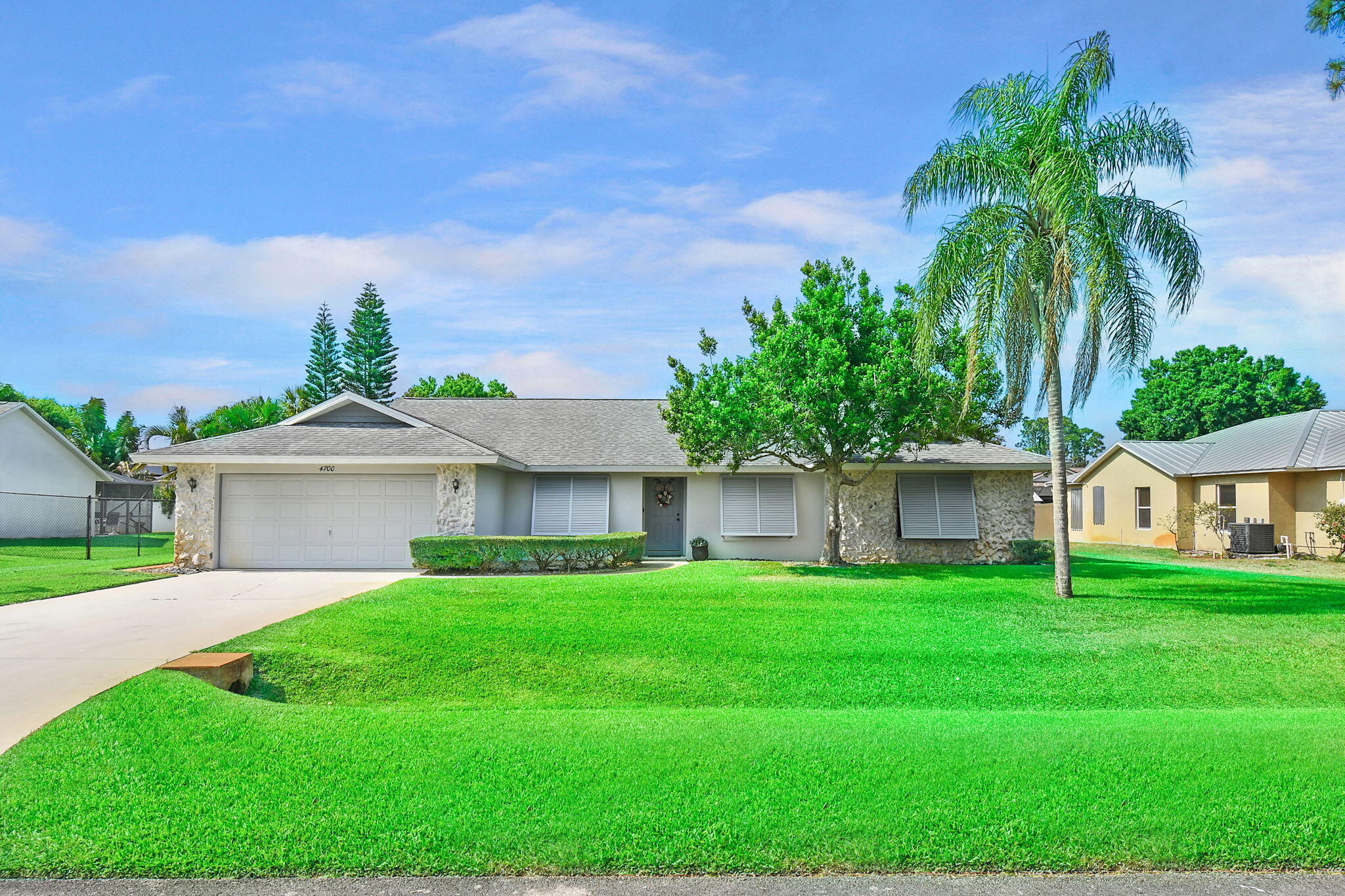 a front view of a house with a yard and potted plants