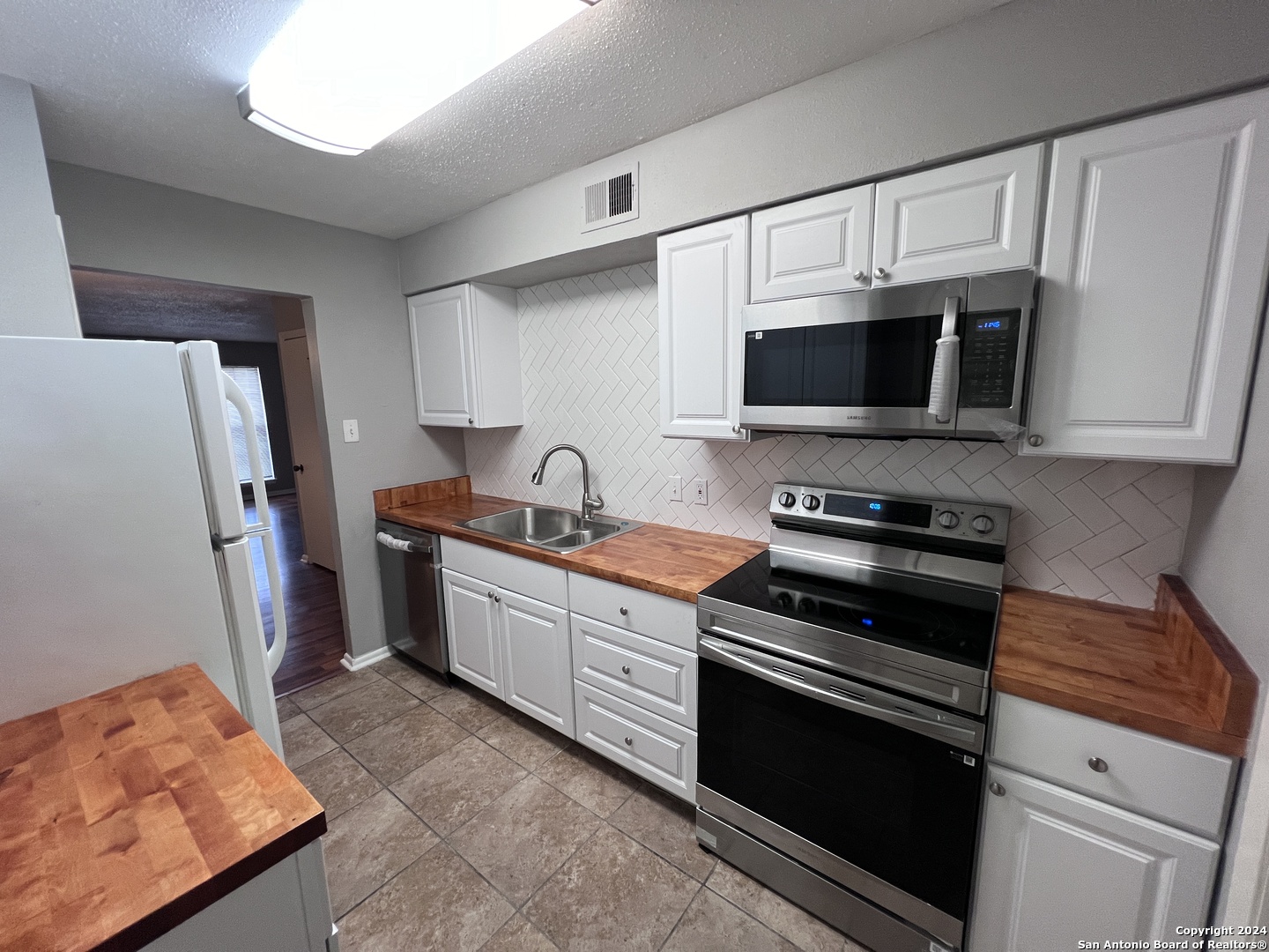 a kitchen with stainless steel appliances a stove microwave and refrigerator