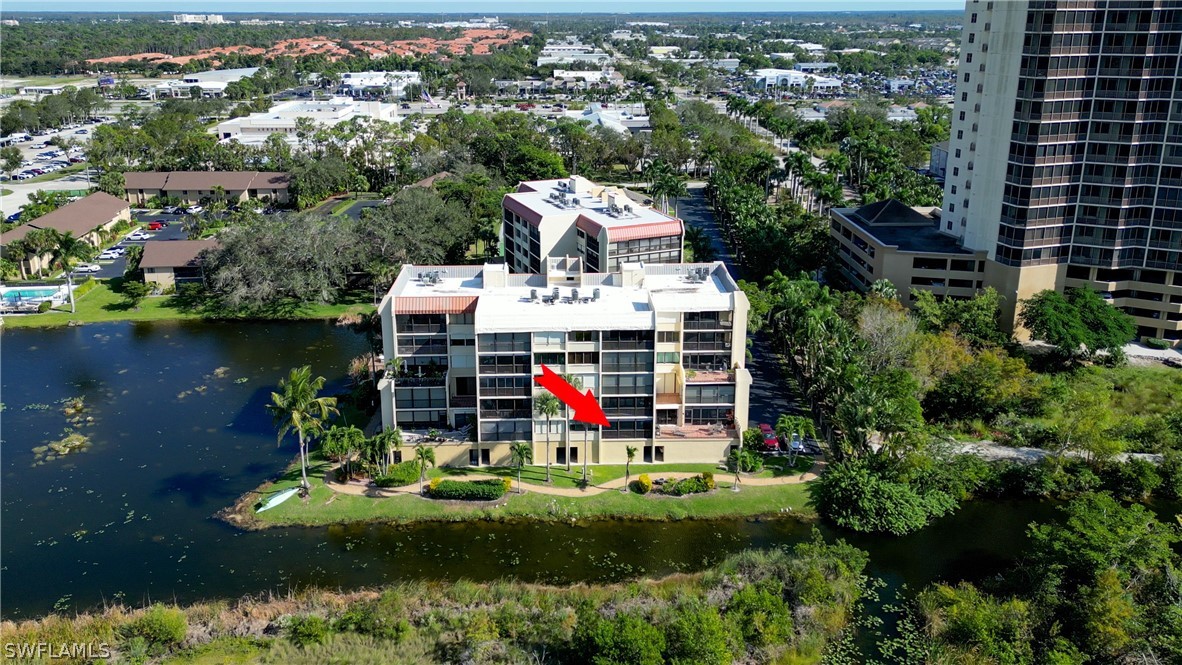 an aerial view of a house with swimming pool and lake view