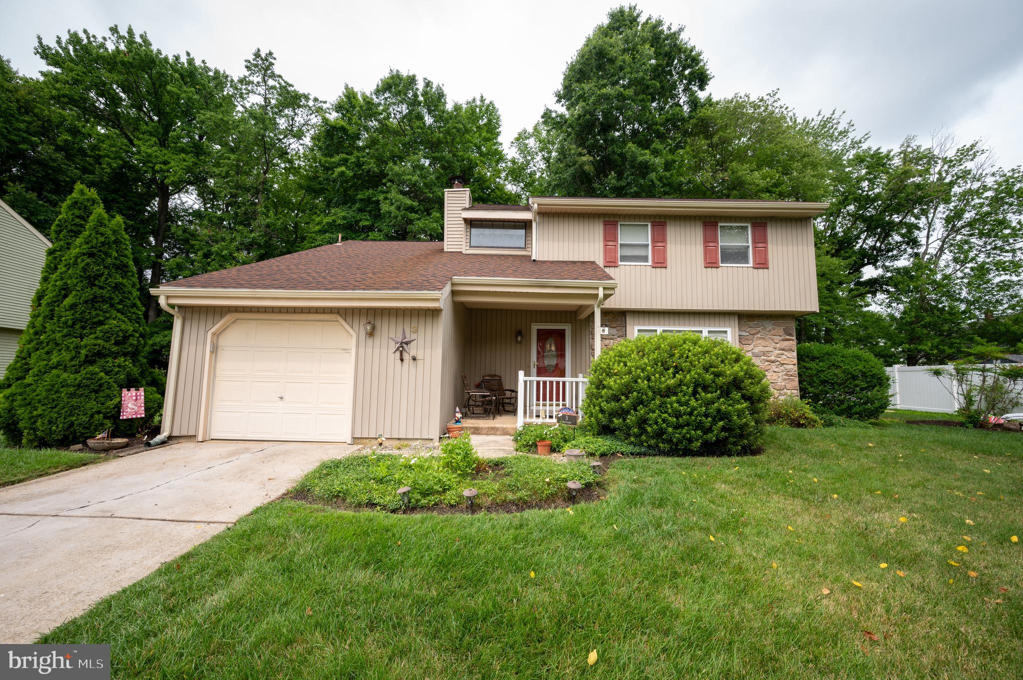 a front view of a house with a garden and yard