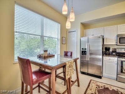 a kitchen with stainless steel appliances granite countertop a table chairs and a refrigerator