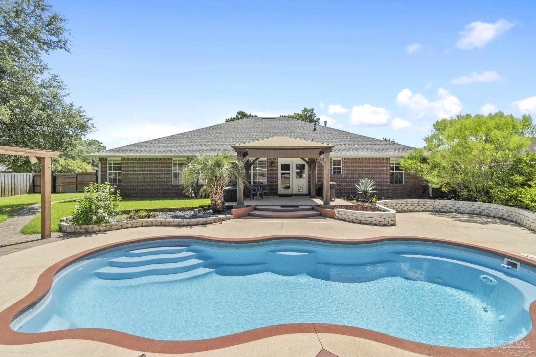 a view of a house with swimming pool and sitting area