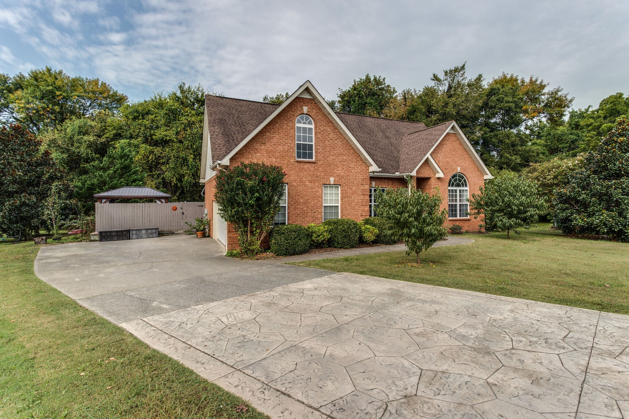 a front view of a house with a yard and trees