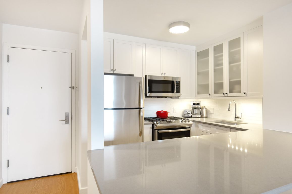 a kitchen with stainless steel appliances a refrigerator sink and microwave