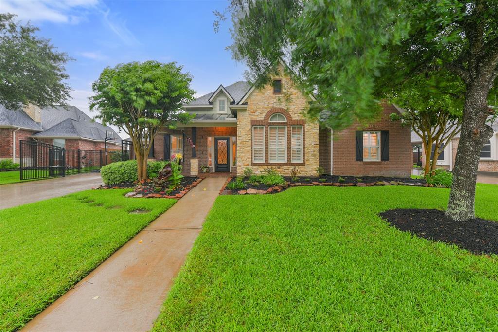 a front view of a house with a garden and trees