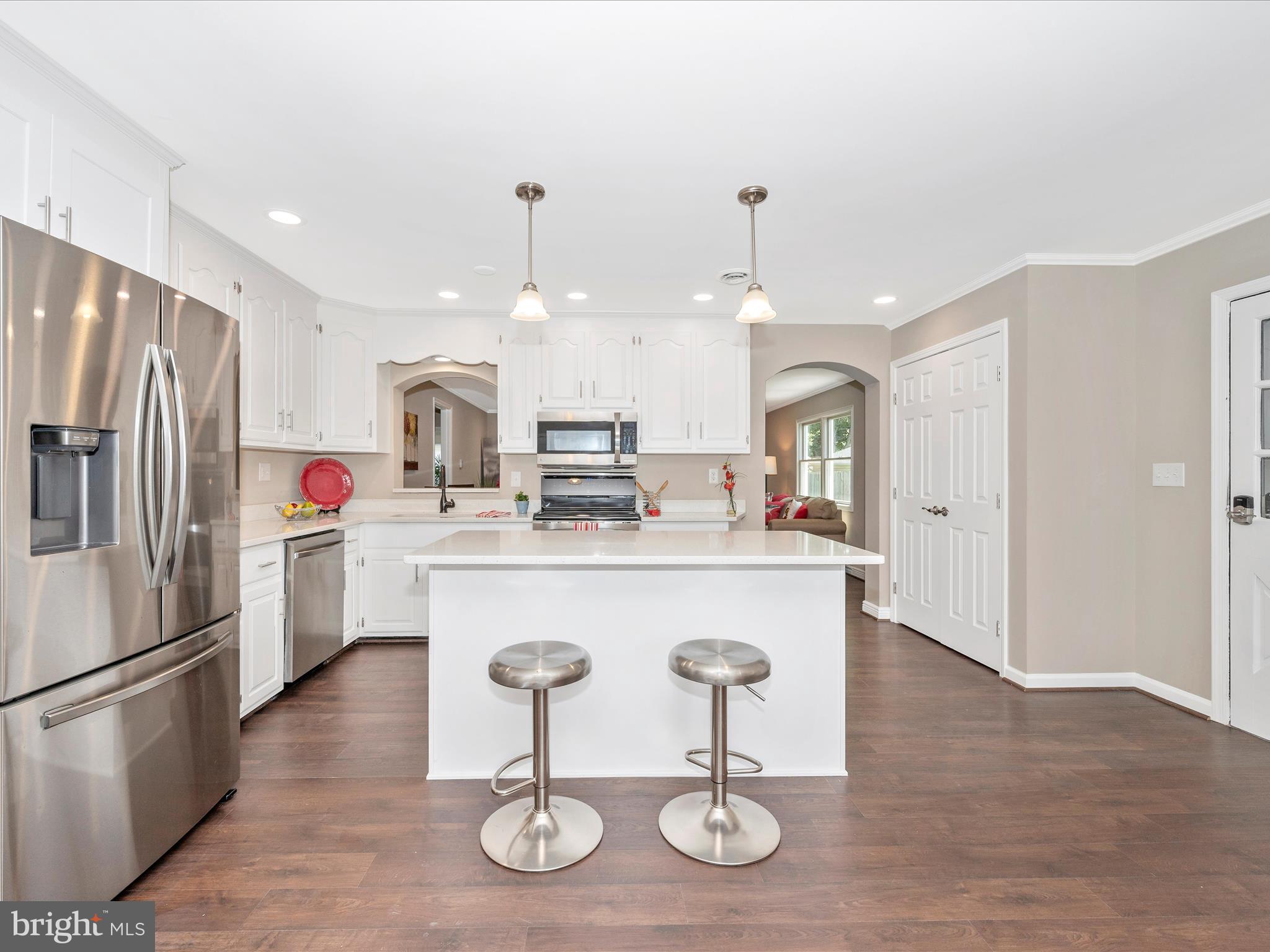 a kitchen with stainless steel appliances kitchen island granite countertop a sink a refrigerator and a stove