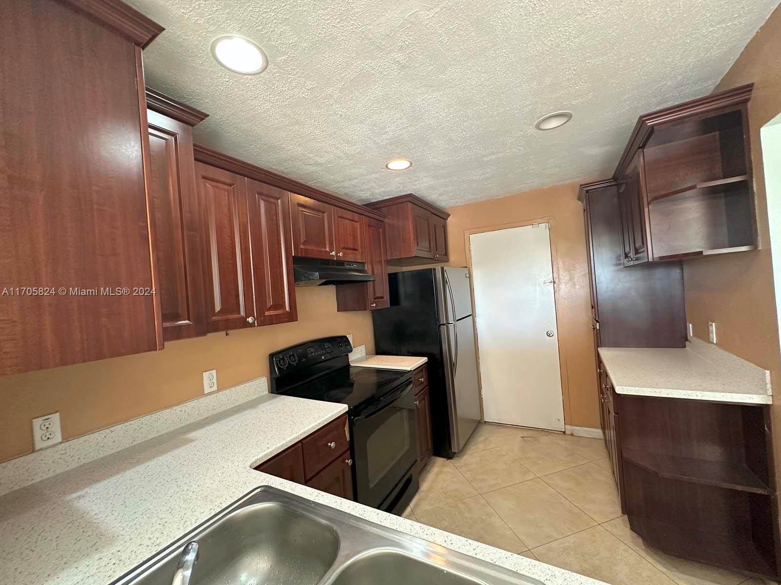 a kitchen with a refrigerator and a sink