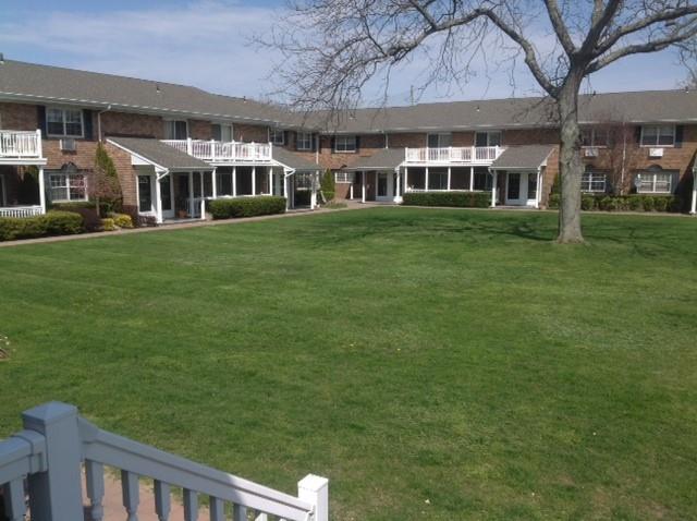 a view of a house with a big yard and large trees