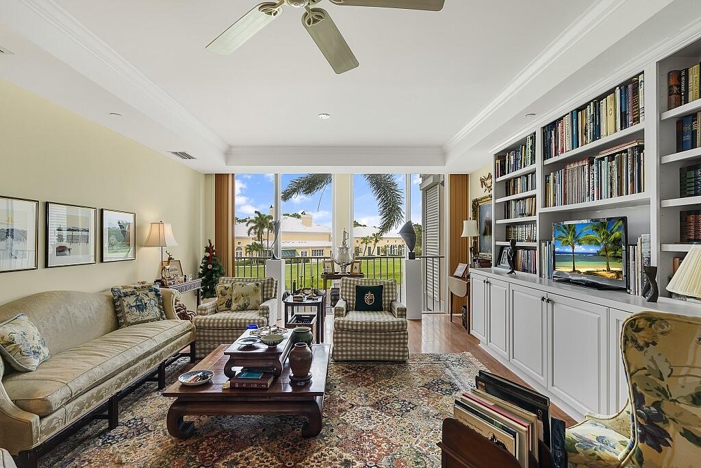 a living room with furniture a bookshelf and a large window