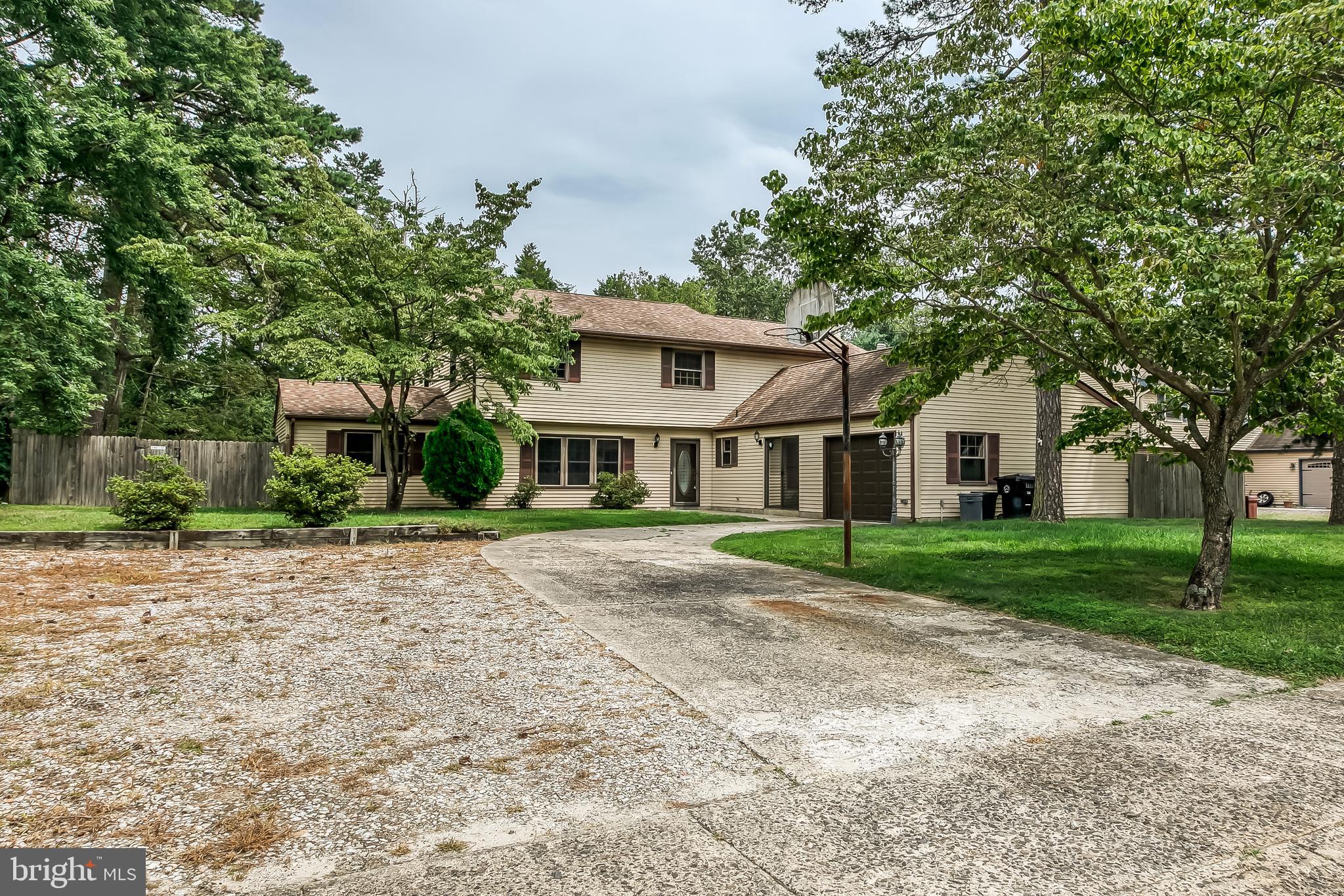 a front view of a house with a yard and trees