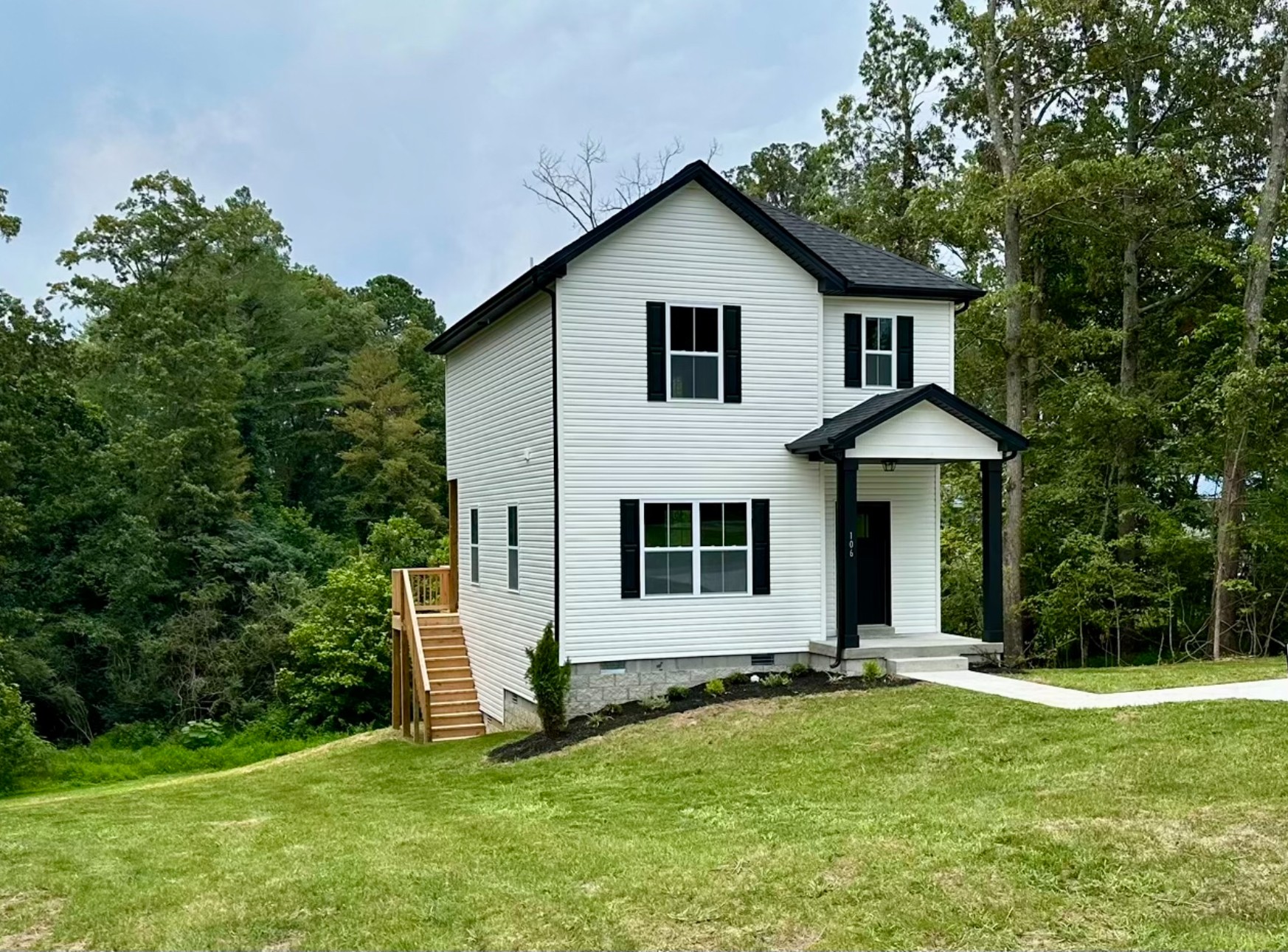 a view of a house with a yard and tree