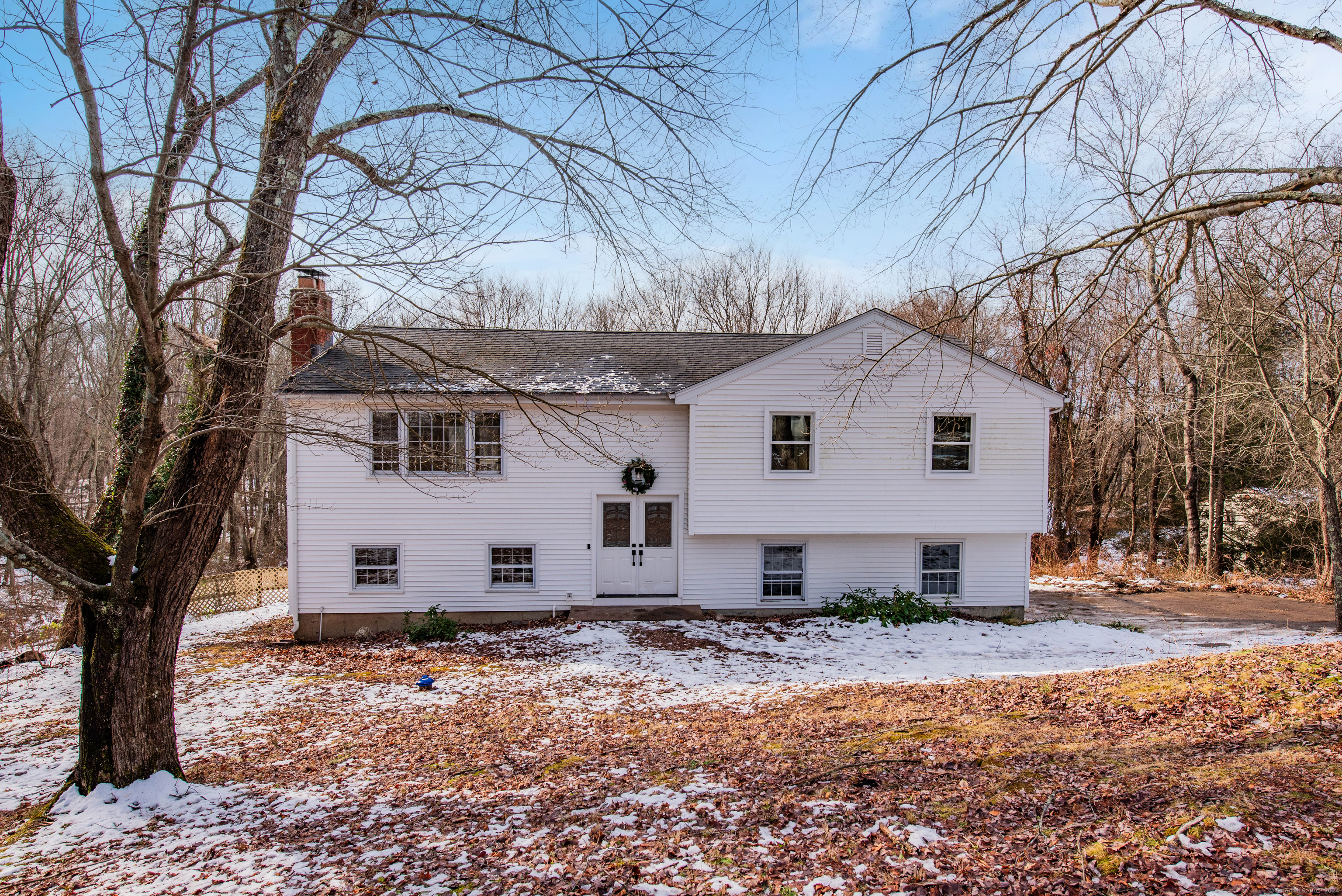 a view of a white house with a yard covered in snow