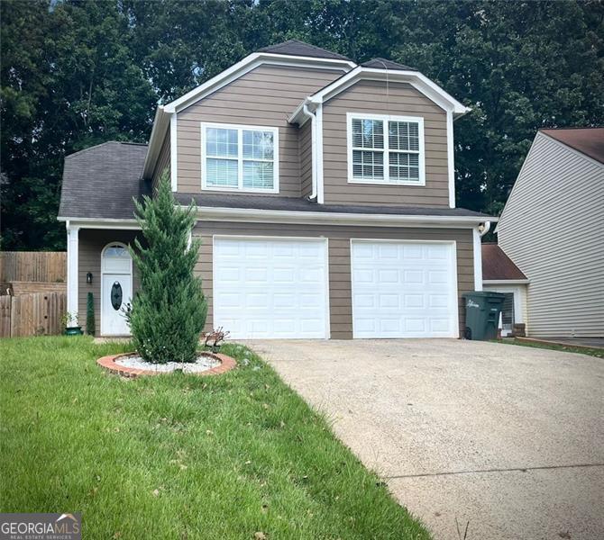 a front view of a house with a yard and garage