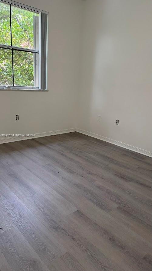 an empty room with wooden floor and window