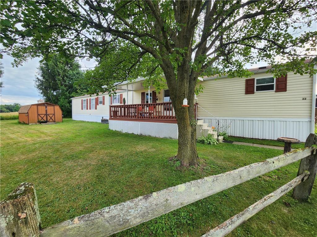 a view of a house with backyard and a tree