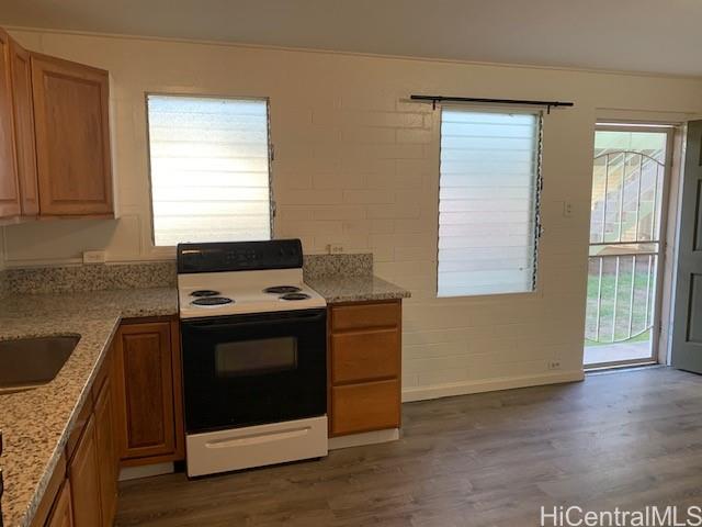 a kitchen with granite countertop wooden cabinets and a stove