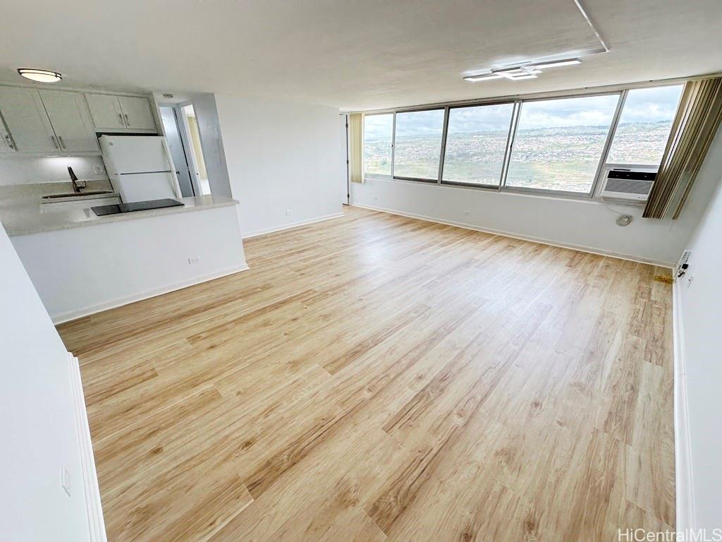 a view of a big room with wooden floor and windows