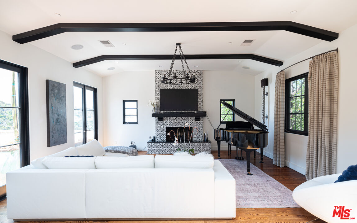 a living room with furniture a chandelier and a flat screen tv