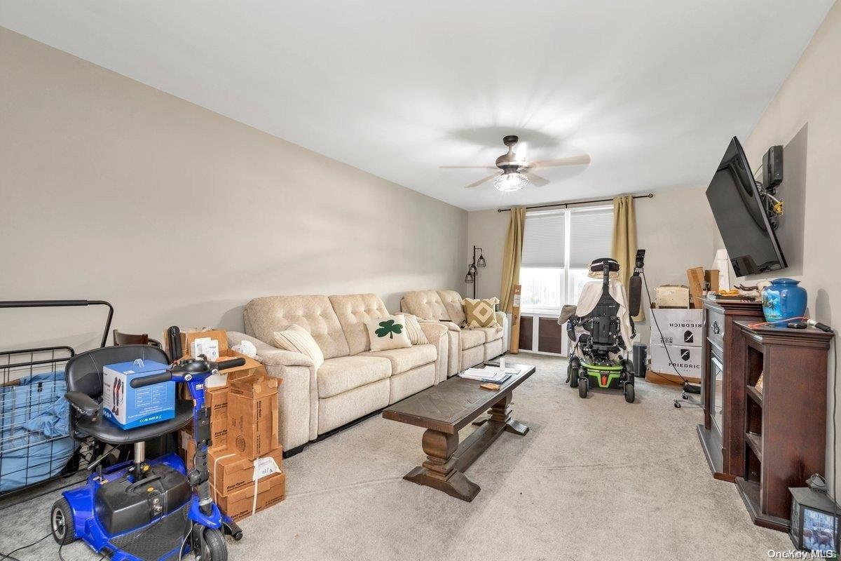 a living room with furniture a flat screen tv and gym equipment