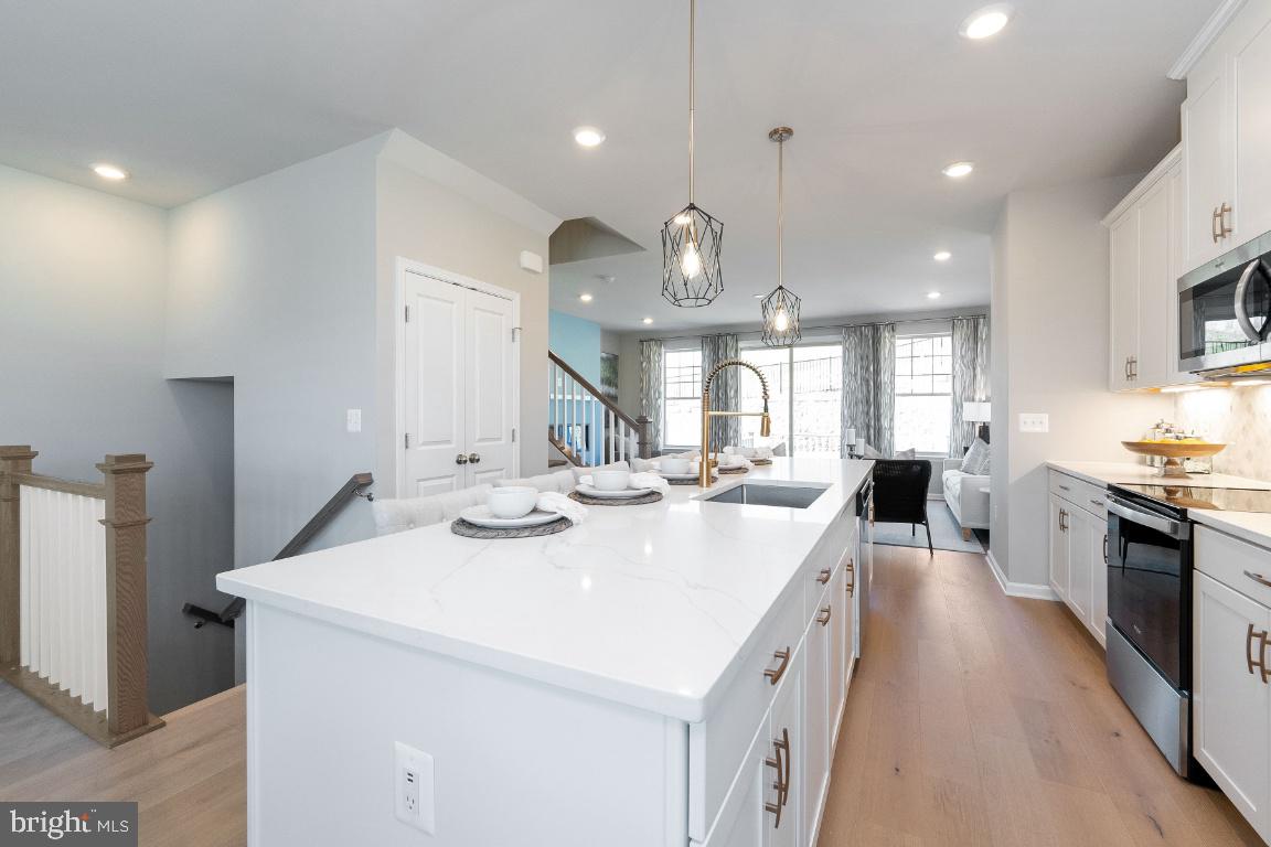 a large kitchen with kitchen island a sink a counter space and stainless steel appliances