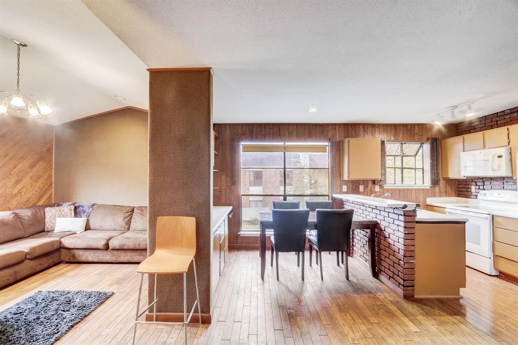 a living room with furniture a dining table and chairs with wooden floor