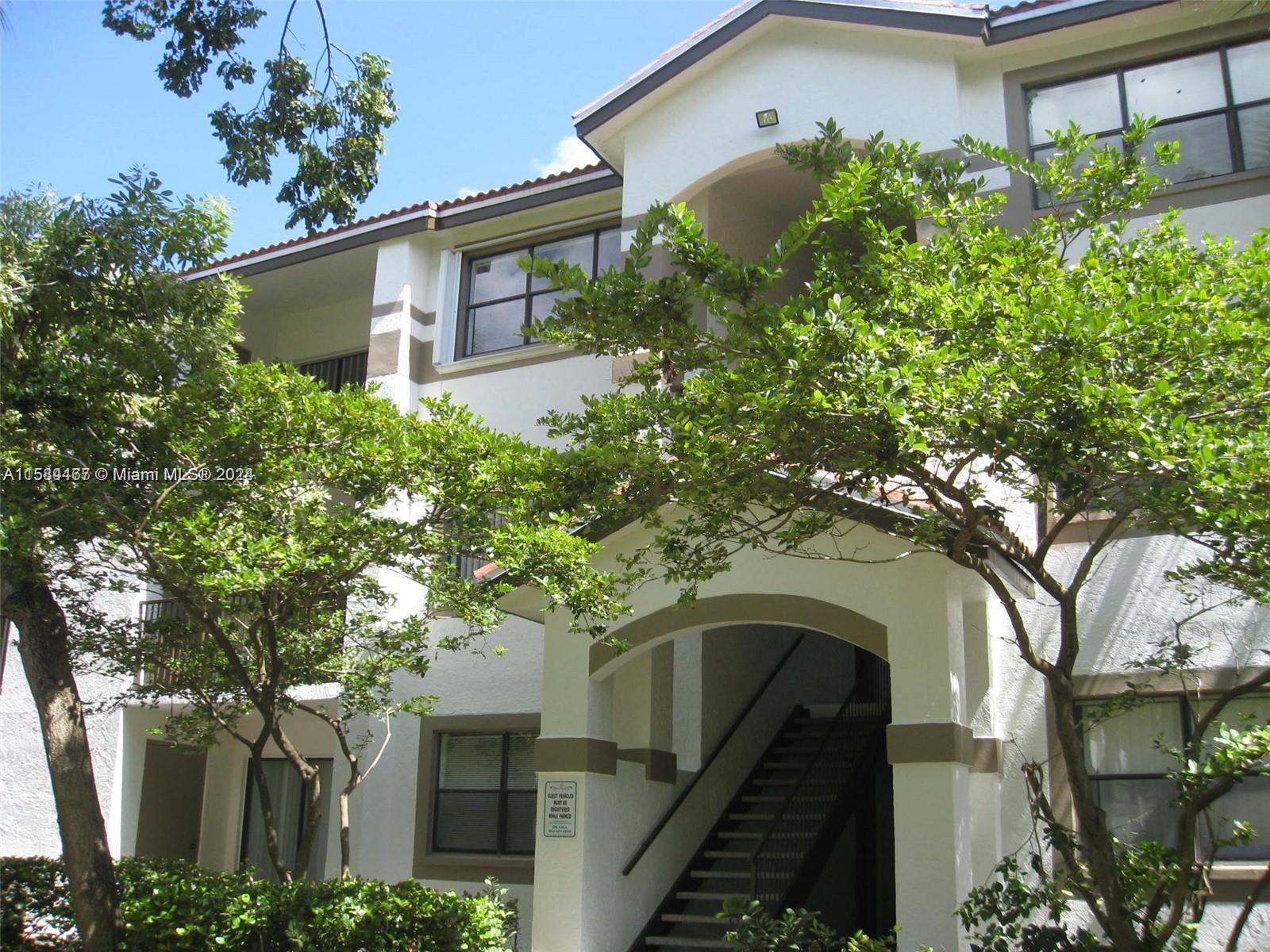 a front view of a house with a tree