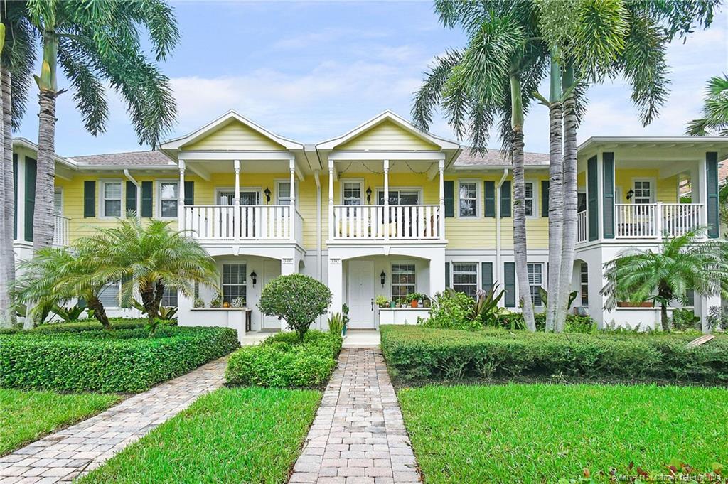 a front view of a house with a yard and potted plants