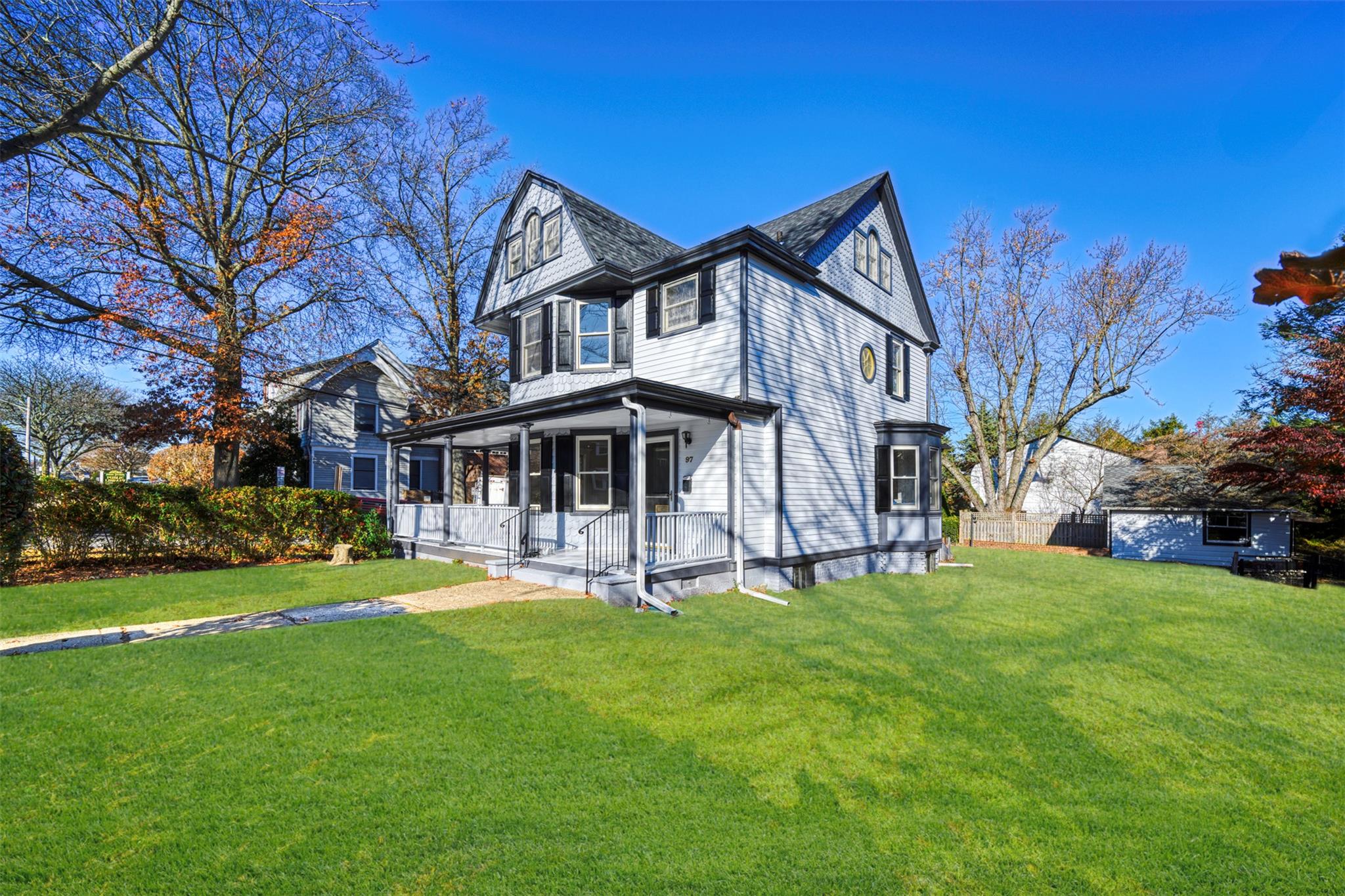 View of front of home with covered porch and a front yard