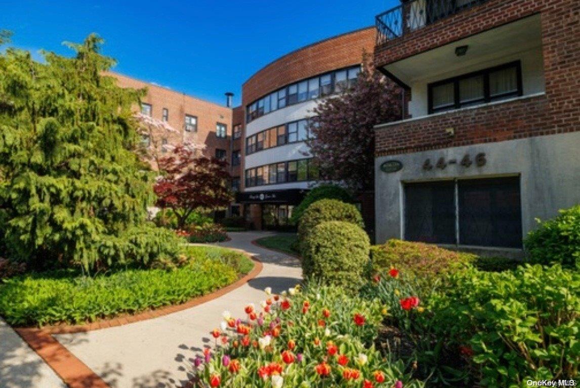 a front view of a building with a garden