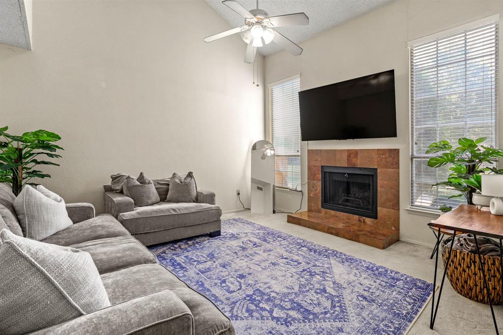 a living room with furniture a flat screen tv and a fireplace