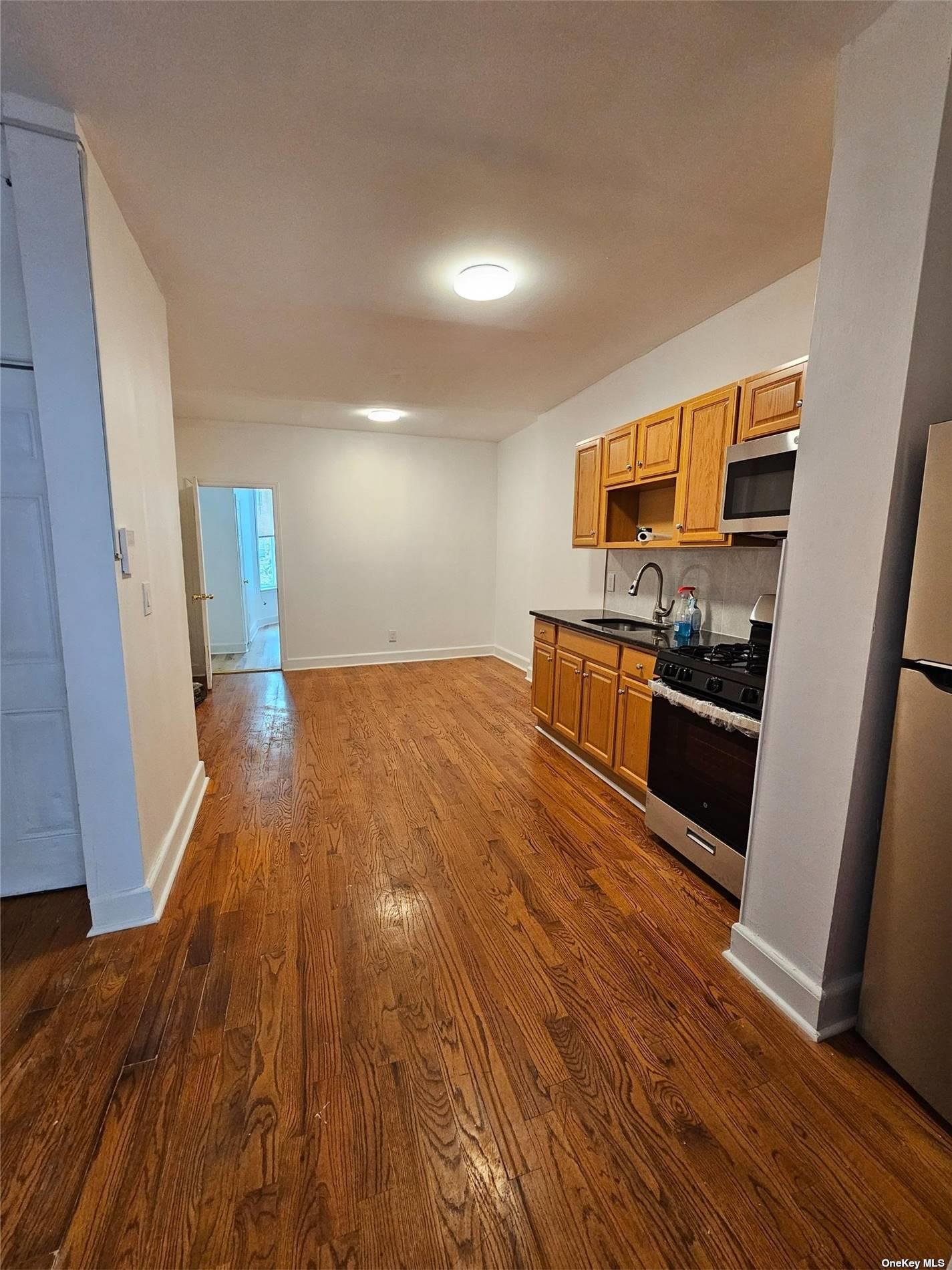 a view of a kitchen with wooden floor and electronic appliances