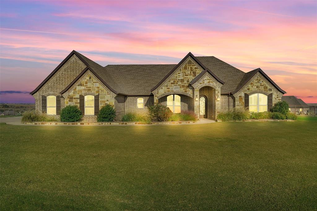 a front view of a house with yard and lake view