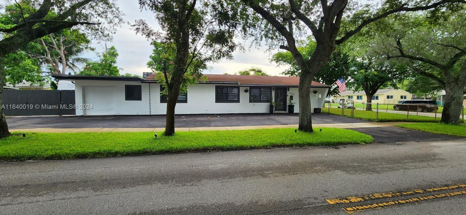 a view of a house with a yard and large tree