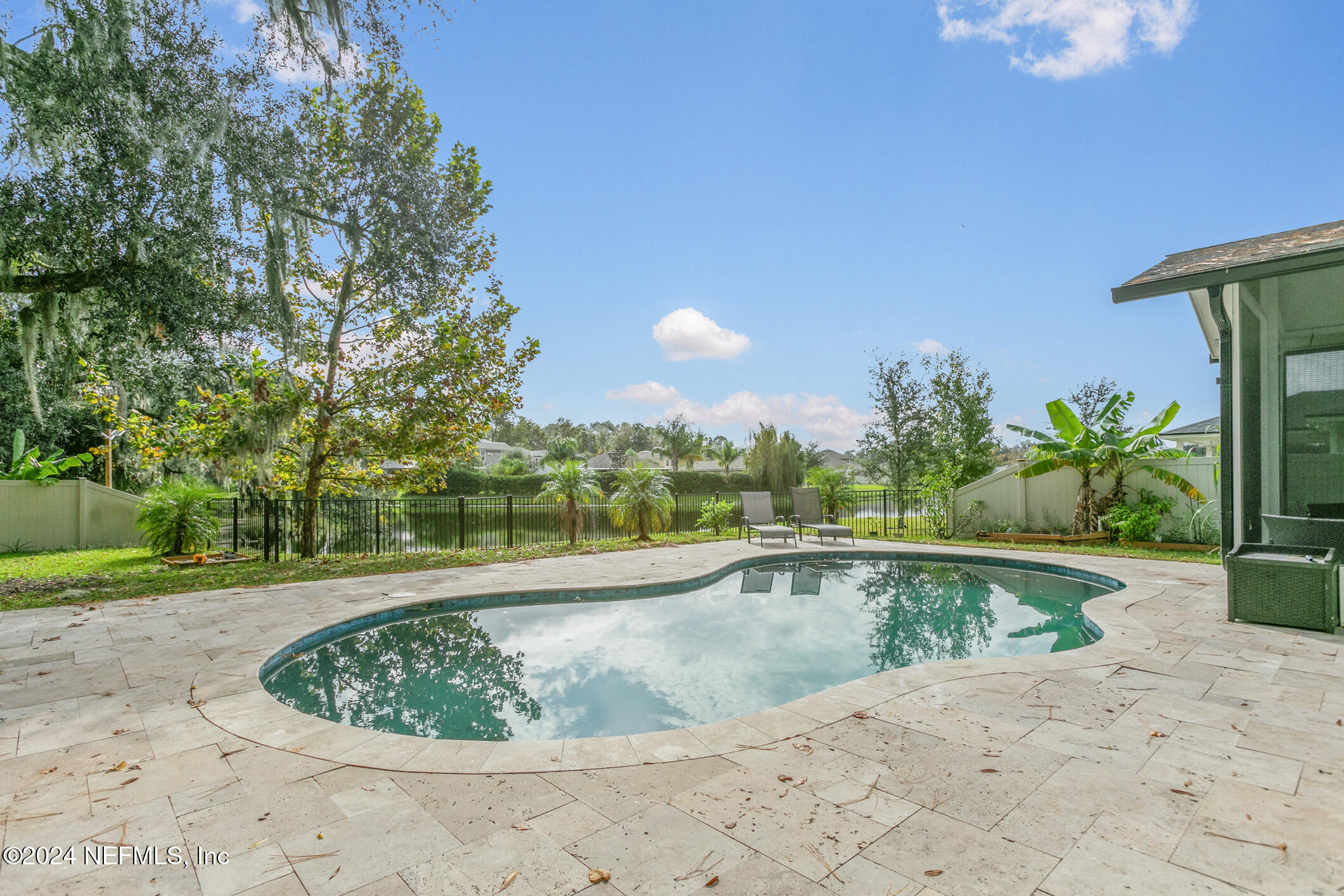 a view of a swimming pool with a patio and plants