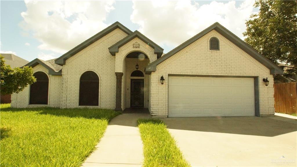 View of front of home with a garage and a front lawn