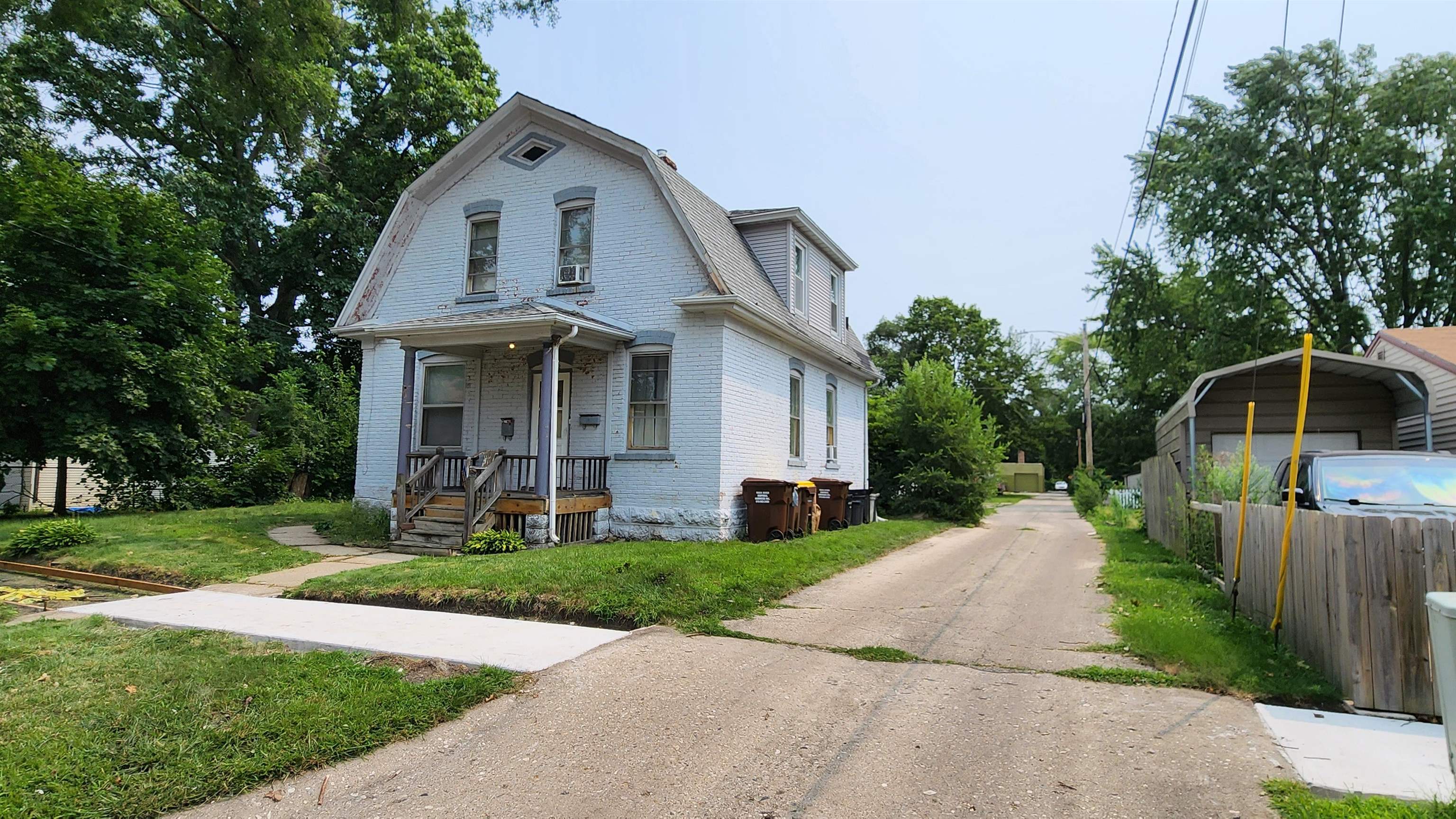 a front view of a house with a yard and trees