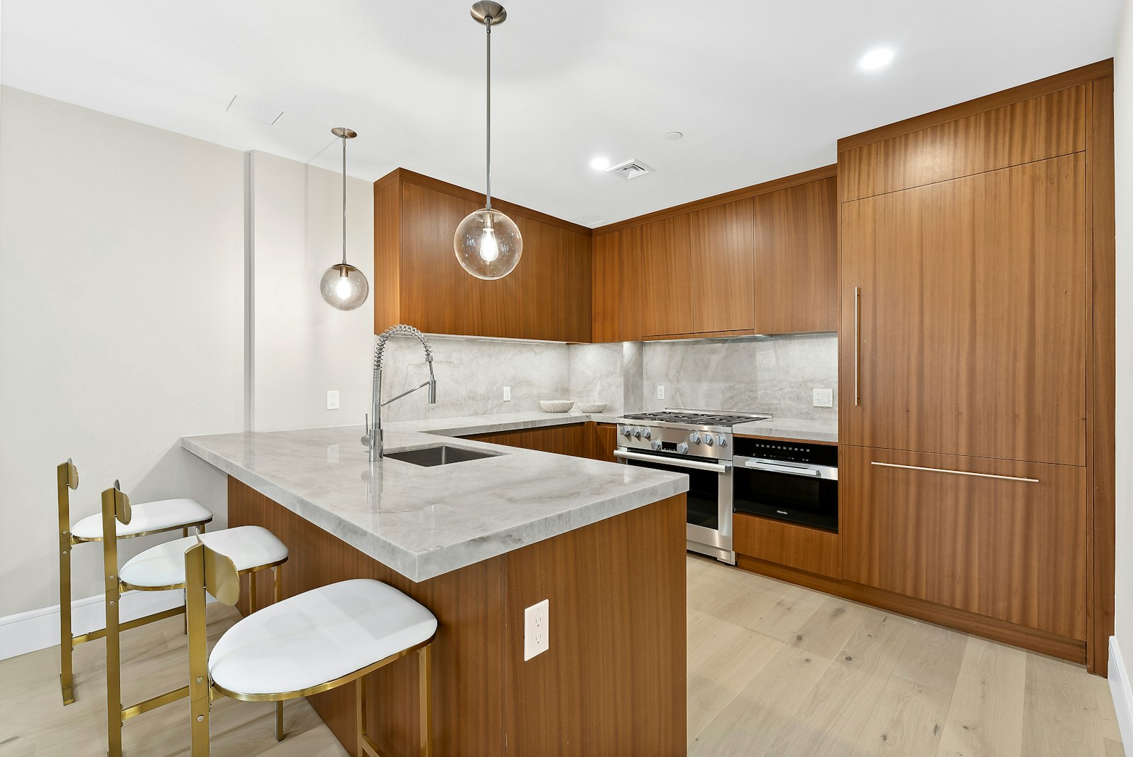 a kitchen with stainless steel appliances granite countertop a sink a stove and a refrigerator