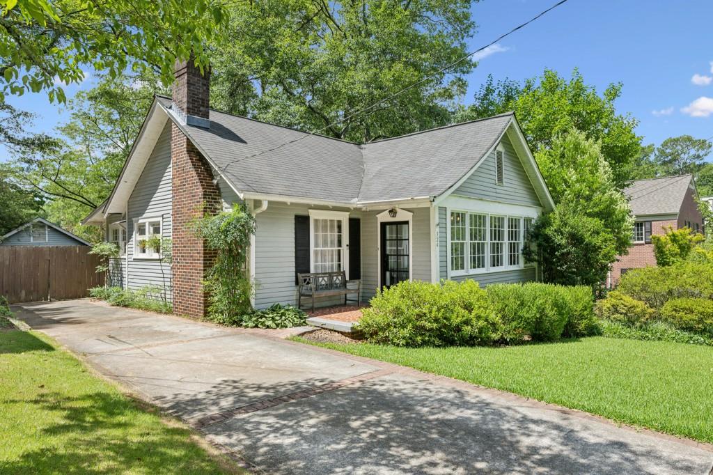 a view of a house with a yard and potted plants