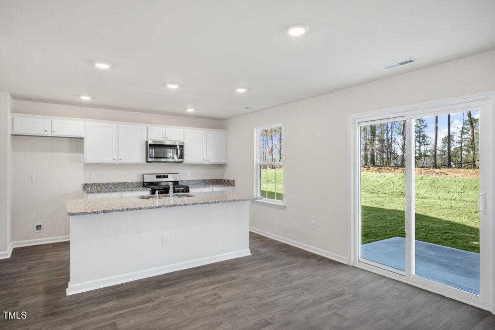 a kitchen with stainless steel appliances granite countertop a stove a sink and a refrigerator